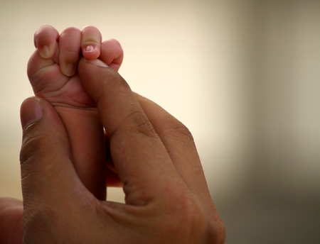 Newborn Baby Holding Father Hand