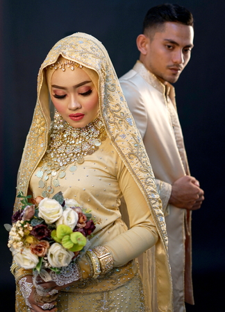 Bride and groom Holding blooms, Indonesian wedding ceremonyの写真素材