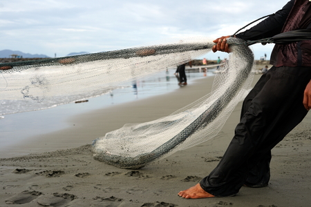 Banda Aceh, Aceh, Indonesia - September 16, 2018: Group of fishermen manually pulls their net out...