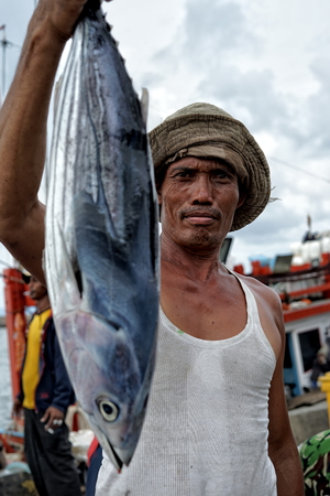Banda Aceh, Indonesia - September 22, 2018: Local fishermen holding fresh catch of tuna fish from their vessels in Lampulo seaport, Banda Acehのeditorial素材