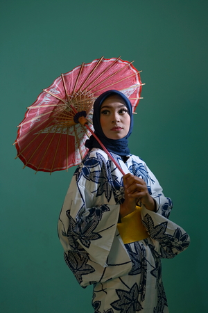 Young Japanese Muslim Girl in Kimono with umbrella