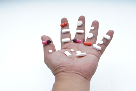 Hands Holding Pills medicine on white backgroundの写真素材