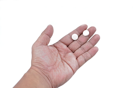 Pill in male hand with white backgroundの写真素材