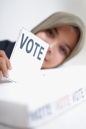 Hijab girl putting a ballot into a Ballot box