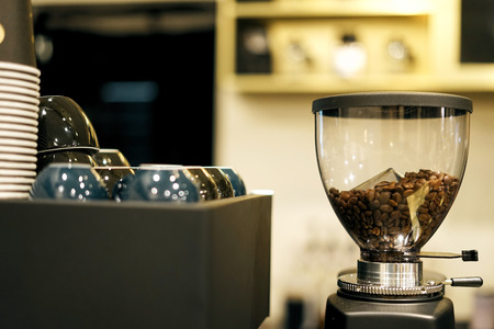 Coffee beans inside coffee grinder at coffee shopの写真素材