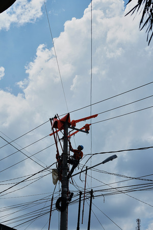 Banda Aceh, Indonesia - April 18, 2019: Two Electrician repair power lines in power substation in Banda Acehのeditorial素材