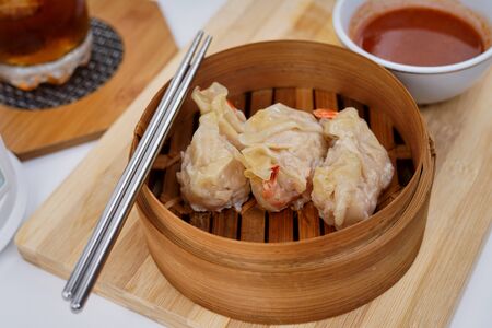 Chinese Dim sum in a bamboo steamer with white backgroundの写真素材