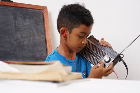 Young boy listening music with a vintage radioの写真素材