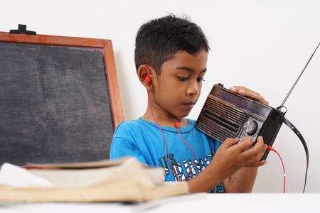 Young boy listening music with a vintage radioの写真素材