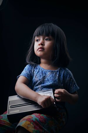 Cute little girl listening to the old radioの写真素材