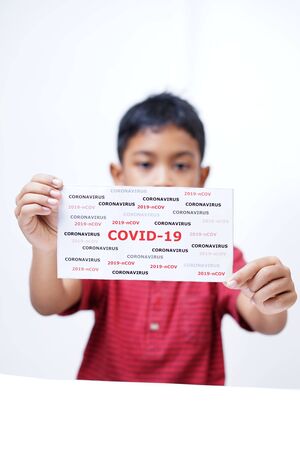 schoolboy holding COVID-19 coronavirus signの写真素材
