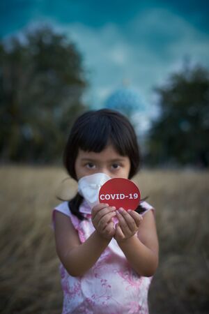 Little Girl in respiratory mask Playing in agricultural Fieldの写真素材