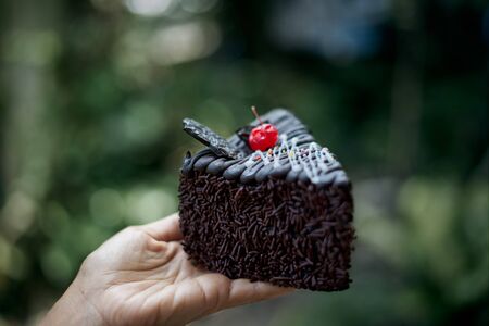 Delicious Slice of chocolate cake with cherry on topの写真素材