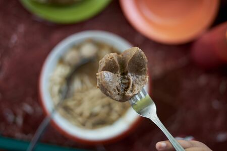 Customer eating Meatballs and Noodles soup and vegetable at street food market. Traditional...