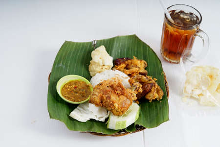 Nasi Uduk Ayam Goreng with Ice Tea, Homemade of famous Indonesian Cuisine.の写真素材