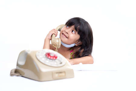 Young Asian toddler Talking on vintage telephone with cute expression