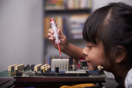 Little cute girl playing with broken computer part, kids creativity study at home during pandemicの写真素材
