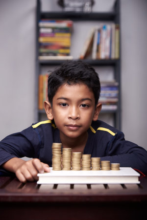 Young Schoolboy is counting his coins for education and businessの写真素材