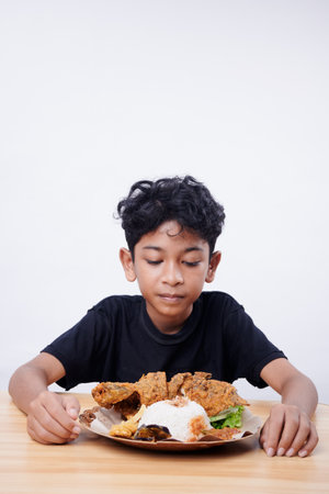 Boy eating Fried Fish and rice at lunch break at schoolの写真素材