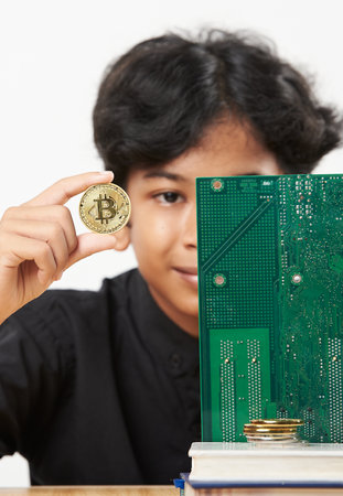 Boy playing with gold Cryptocurrencies coin with isolated white background