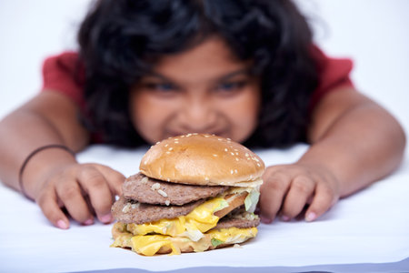 A little girl with an appetizing burger, Close-up focus on Burgerの写真素材