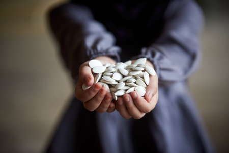 Close-up of woman hands holding pumpkin seeds. Selective focus.の写真素材