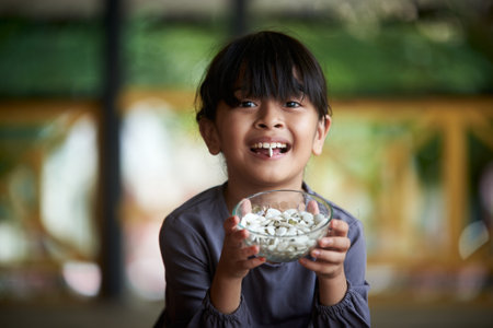Little girl holding a pile of healthy pumpkin seedsの写真素材