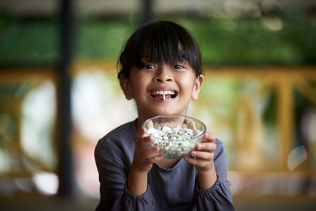 Little girl holding a pile of healthy pumpkin seeds