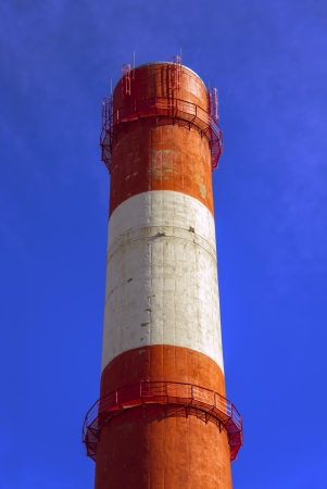Striped power plant tube on blue skyの写真素材