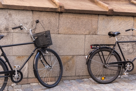 Two old classic bicycles near the stone wallの写真素材