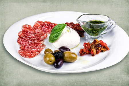 restaurant dish consisting of meats, olives, egg and sauceの写真素材