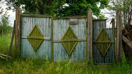 Old destroyed wooden gate with a wicket in the countrysideの写真素材