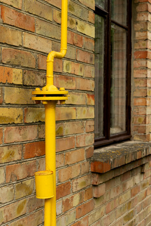 Gas reducer with yellow pipe along the wall of a house in the countrysideの写真素材