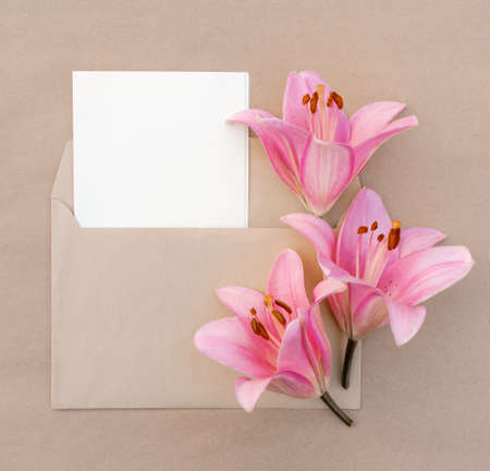 card with a bouquet of pink lilies in an envelope with copy space for design