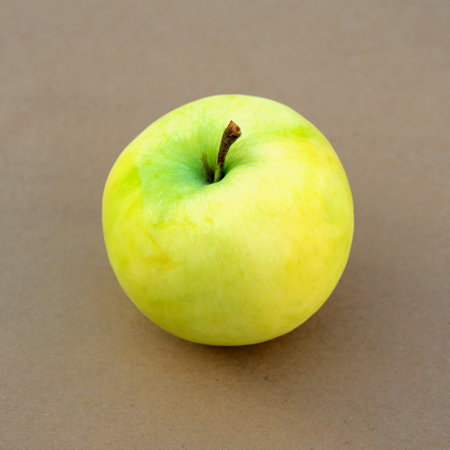 Ripe juicy yellow-green apple on a wood backgroundの写真素材