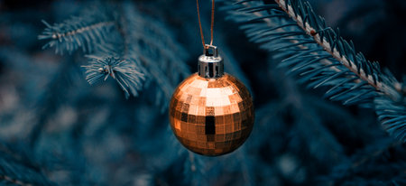 Background of green twigs of a Christmas tree with shiny colorful ball.の写真素材