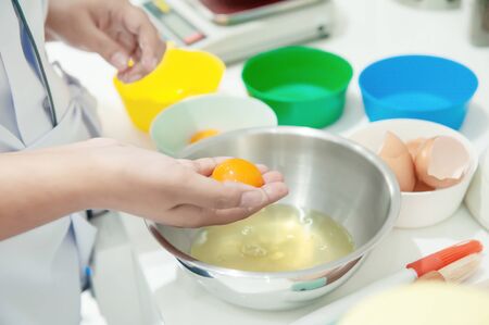 Separate egg yolk on the hands female for made bakery ingredient and cookingの写真素材