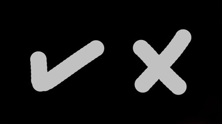 closeup of a black background with white checkmark and cross markの写真素材
