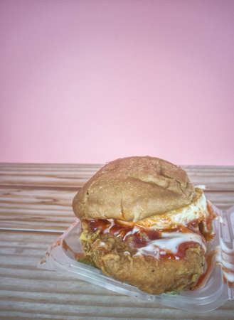 Double fried chicken burger with eggs, mayo, salad, cheese and chilli sauce. Selective focus points....