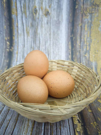 Three raw eggs in a rattan basket. Selective focus points