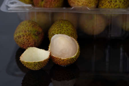 A close-up of a peeled green lychees with blurred whole fruit in the background. Selective focus points.の写真素材