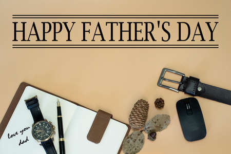 Happy Father's Day concept with belt, mouse, dried pine cones and leaves, pen, wristwatch, notebook...