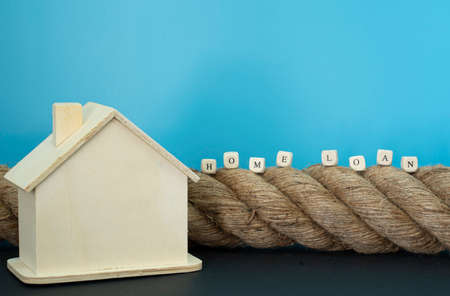 Financial concept. Rope, house model and wooden blocks with text. Selective focus points.の写真素材