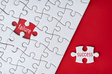Business concept. Jigsaw puzzle with text failure and success on red background. Selective focus...