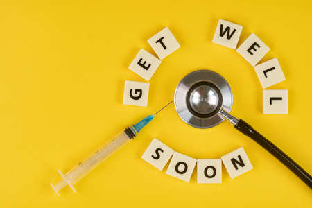 Medical concept. Layout of alphabet blocks, a syringe and a stethoscope with text Get Well Soon. Selective focus pointsの写真素材