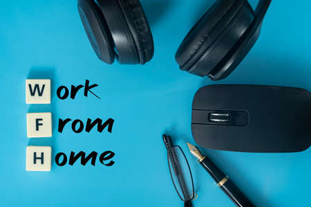 Business concept. Layout of headphones, mouse, pen, glasses and text work from homeの写真素材