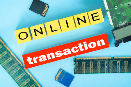 Business concept. Layout of RAM disks, memory cards, small motherboard, wooden blocks and text online transactionの写真素材