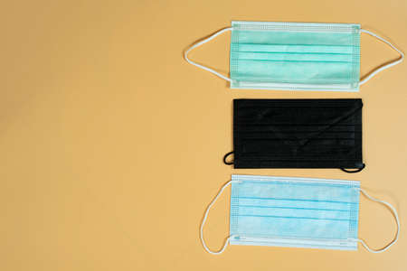 Standard 3-ply face masks as protection during the pandemic on light brown background. Selective focusの写真素材