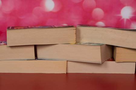 Stack of books arranged randomly on top of each other. Selective focus points. Blurred background