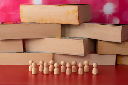 Stack of books with wooden figurines. Selective focus points. Blurred backgroundの写真素材